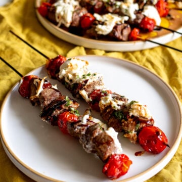 boneless petite sirloin steak skewers with burrata and balsamic drizzle and roasted tomatoes.