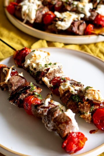 boneless petite sirloin steak skewers with burrata and balsamic drizzle and roasted tomatoes.