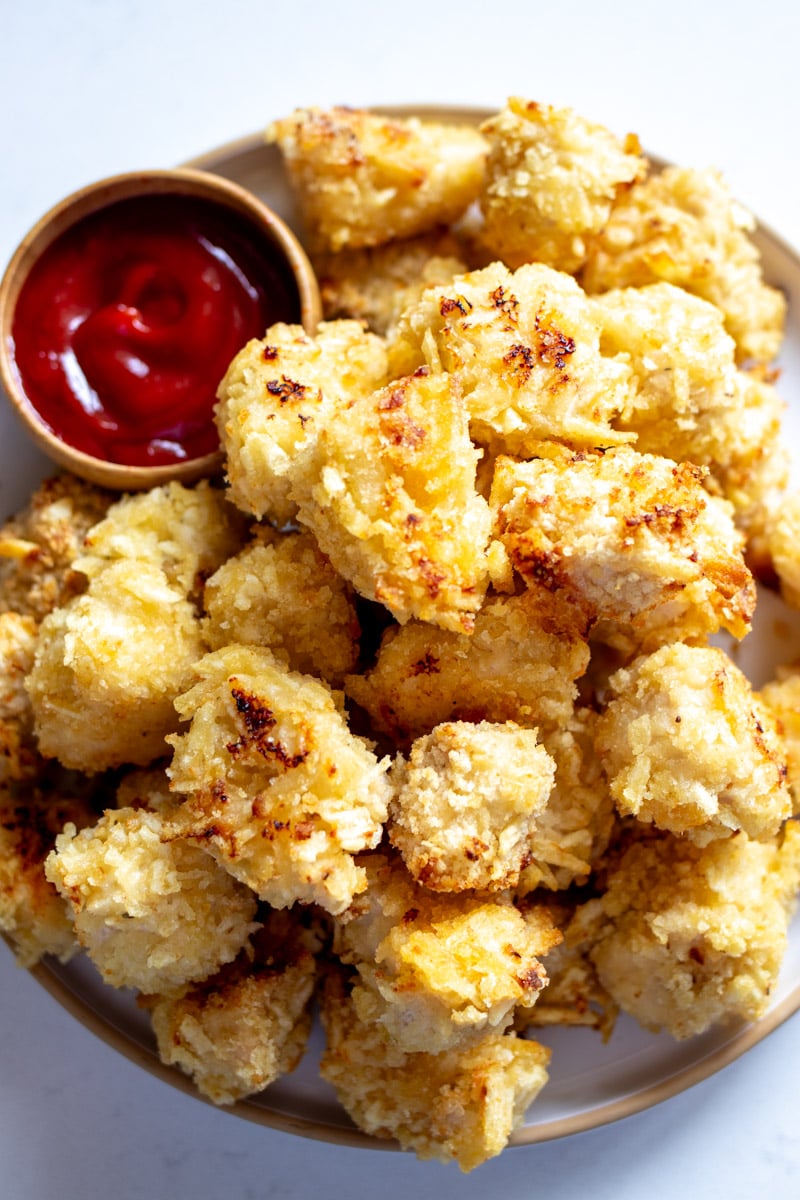 an overhead view of a platter of potato chip crusted popcorn chicken nuggets.