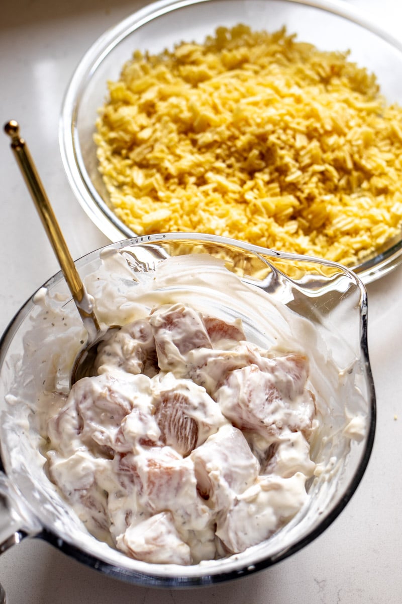 chunks of chicken marinating in french onion dip. 