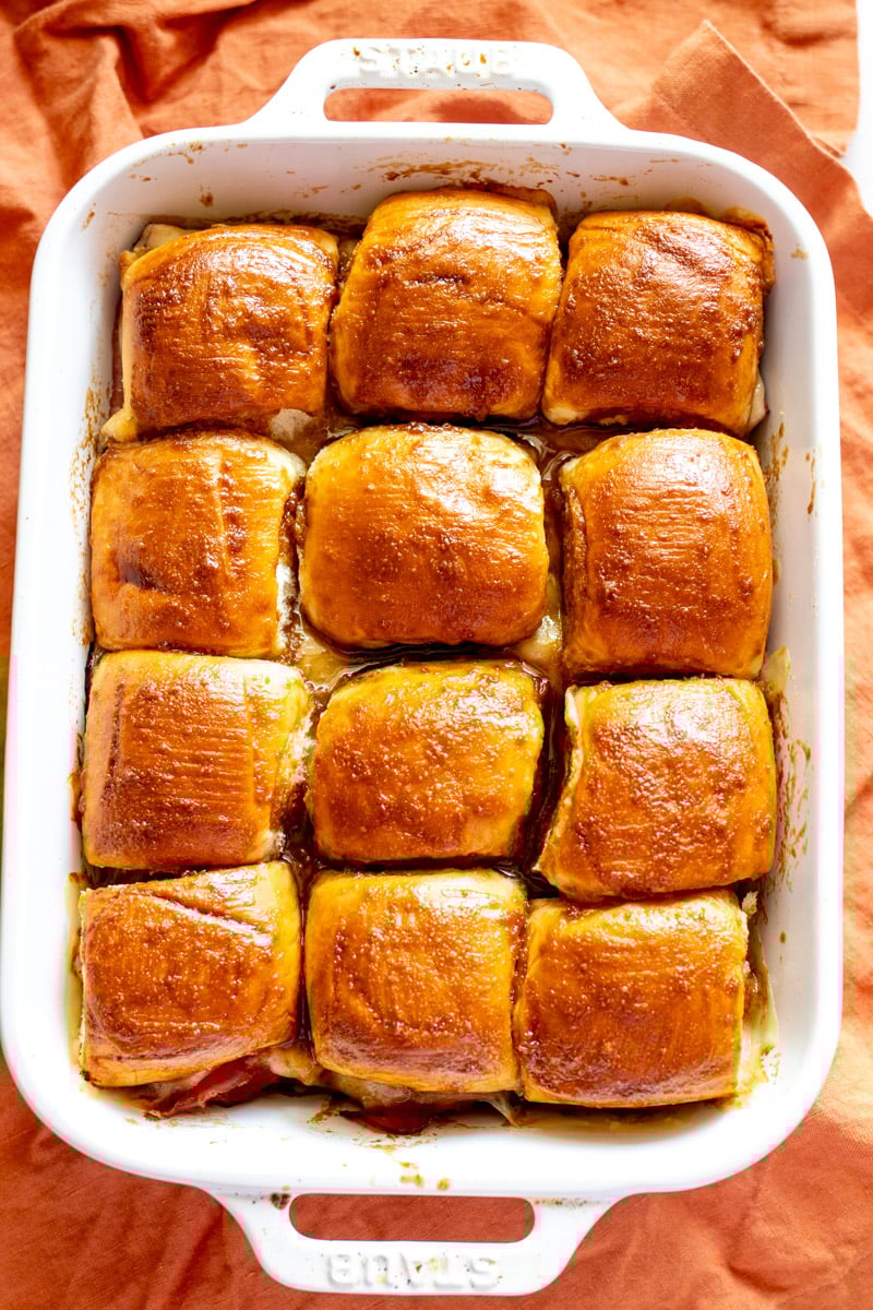 funeral sandwiches in a baking dish on top of a golden orange cloth.