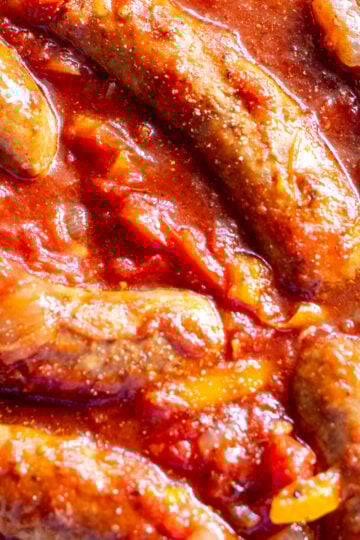 an overhead view of tender sauasage, bell peppers and onions in a crockpot.