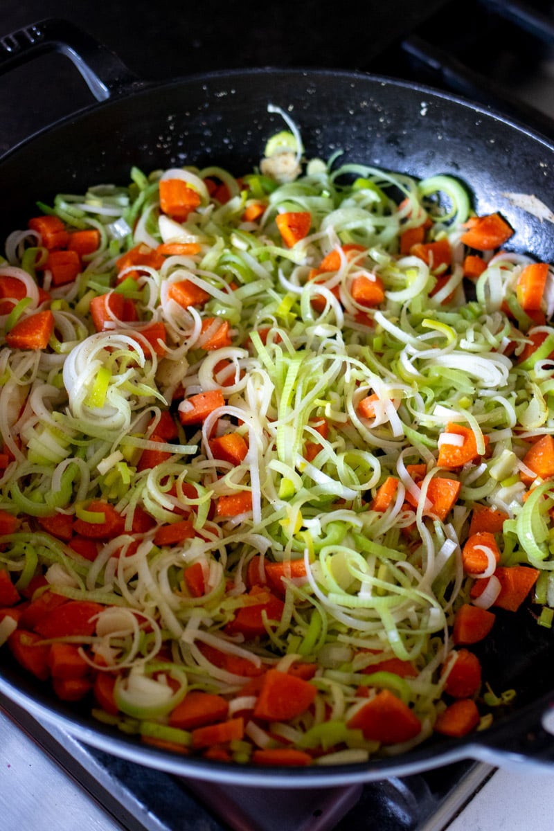 leeks, carrots and onions in a sautee pan. 