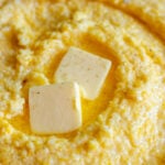 cheesy polenta in a bowl with melted butter on top.
