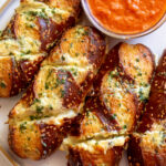 a close up of disneyland's famous cheesy garlic pretzel bread from maurice's treats.