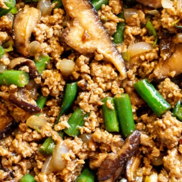 an up close look at the texture of this ground pork stir fry with green beans, mushrooms and onions and asian sauce.