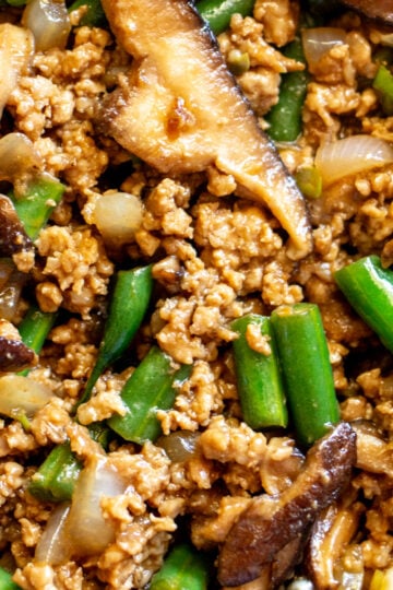 an up close look at the texture of this ground pork stir fry with green beans, mushrooms and onions and asian sauce.