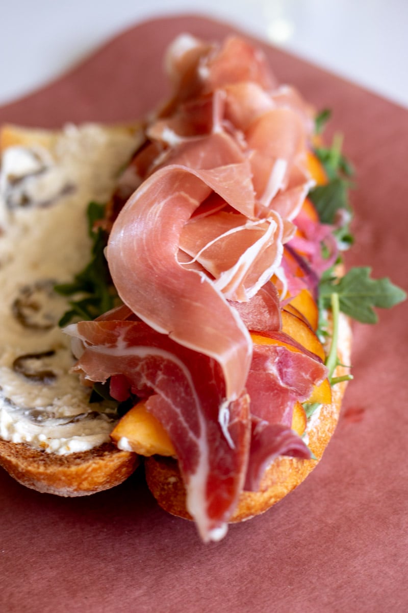 the ingredients for this sandwich all piled on top of crusty bread.