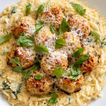 an overhead view of chicken ricotta meatballs with lemony spinach alfredo orzo.