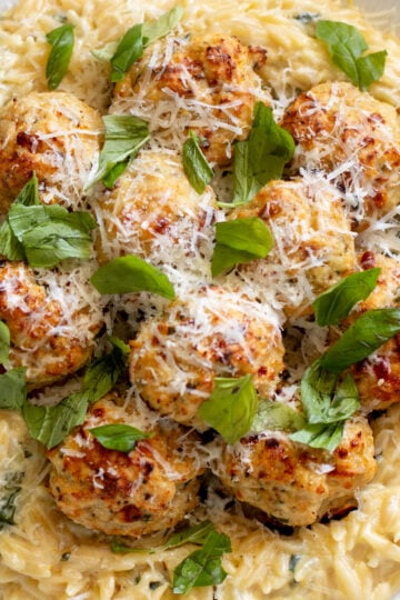an overhead view of chicken ricotta meatballs with lemony spinach alfredo orzo.