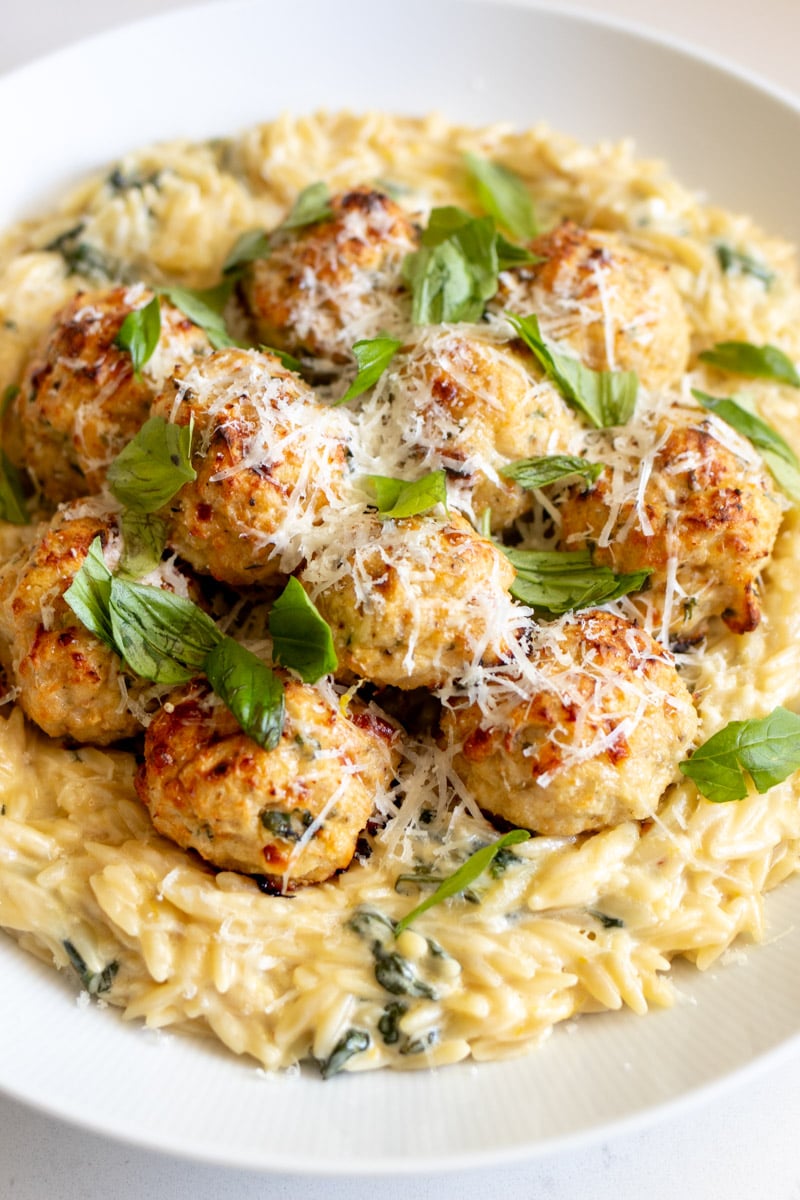 an overhead view of chicken ricotta meatballs with lemony spinach alfredo orzo.