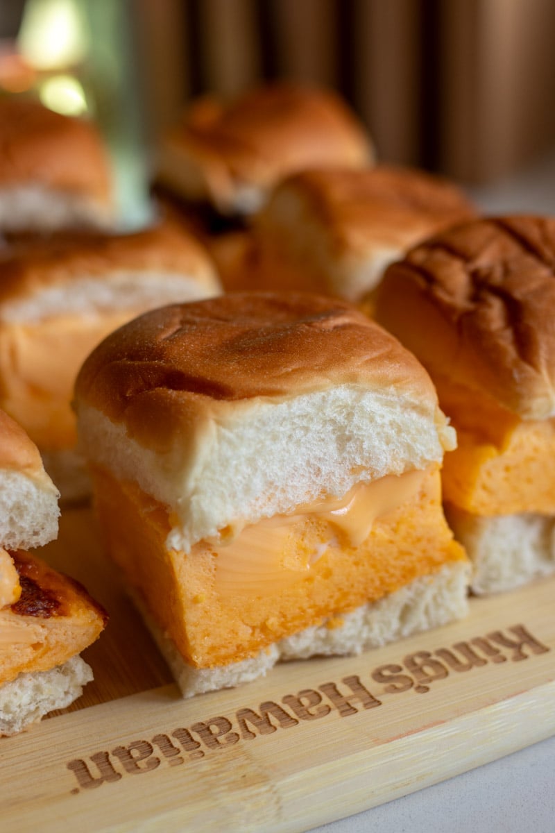 a platter full of fluffy egg sandwiches on hawaiian rollls.