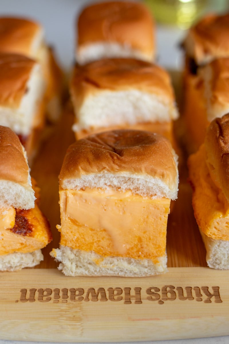 a cutting board full of fluffy egg sandwiches on kings hawaiian rolls.