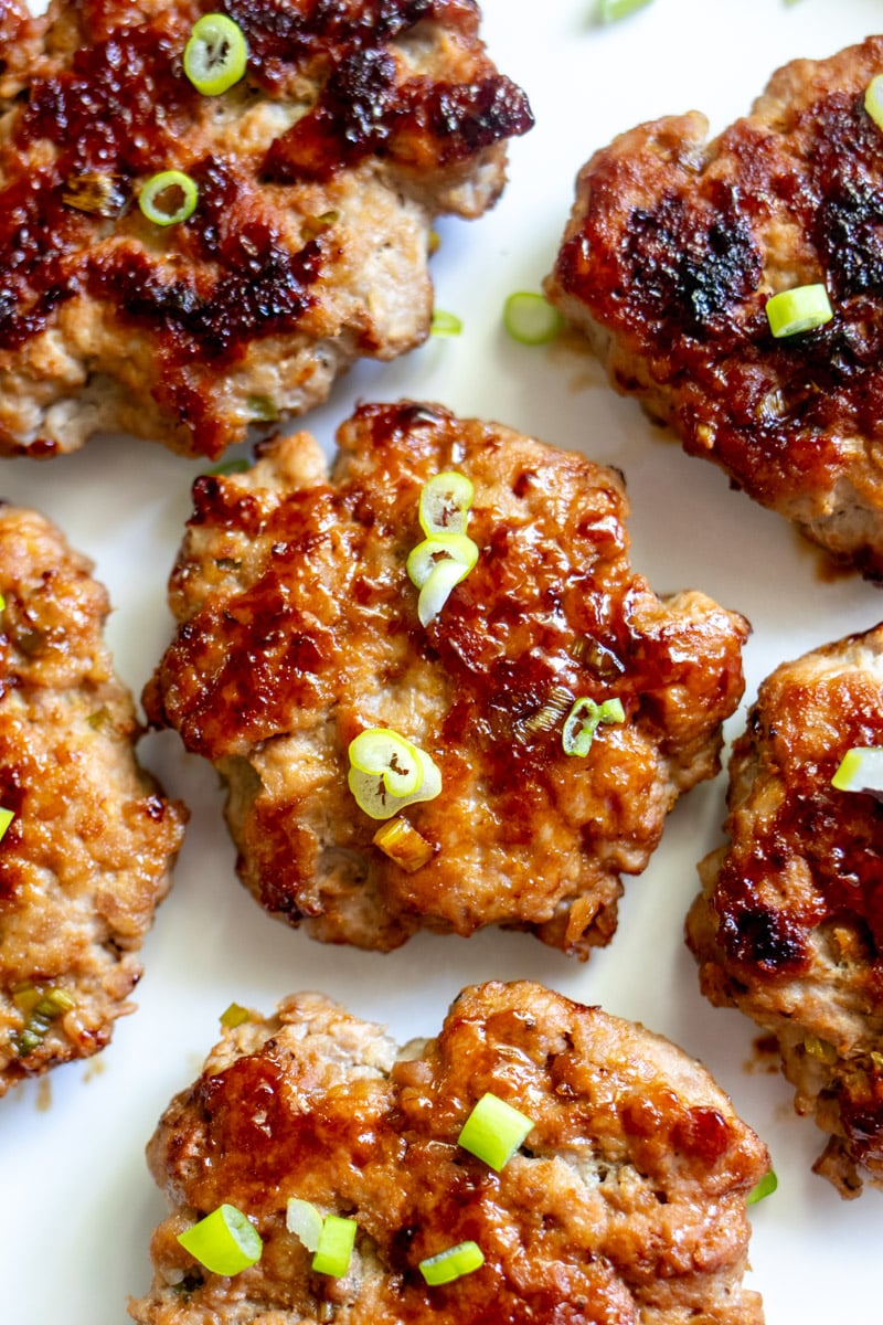 a macro view of the texture of these lemongrass turkey sausages with green scallions on top.