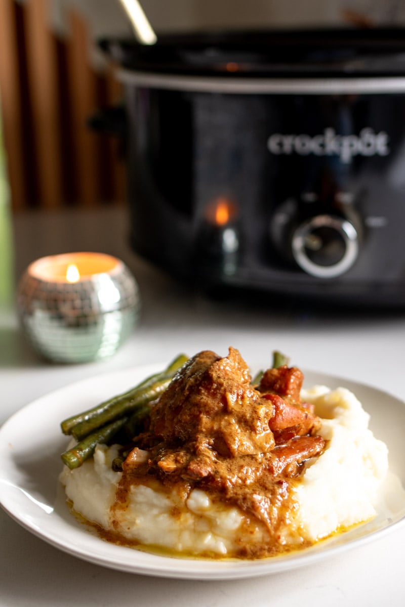 a plate of honey mustard chicken thighs with a crockpot in the background.