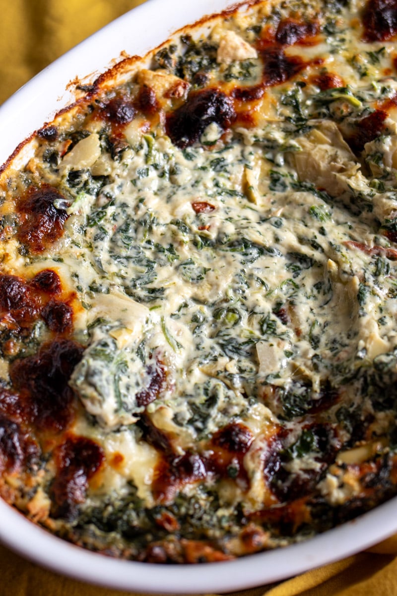 inside the cheesy interior of a baking dish of cheesy spinach artichoke dip.