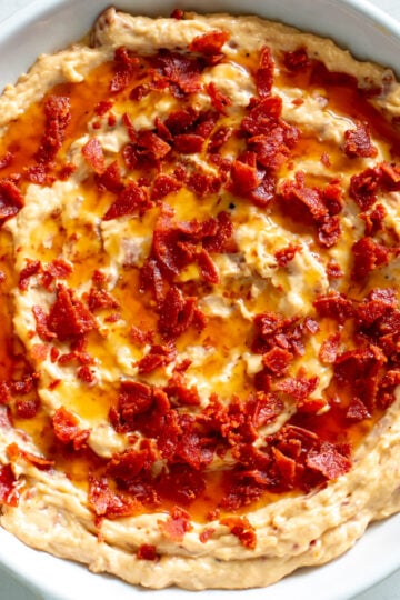 a white bowl full of creamy pepperoni caesar dip.