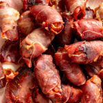 an up close look at a bunch of crispy prosciutto wrapped dates.
