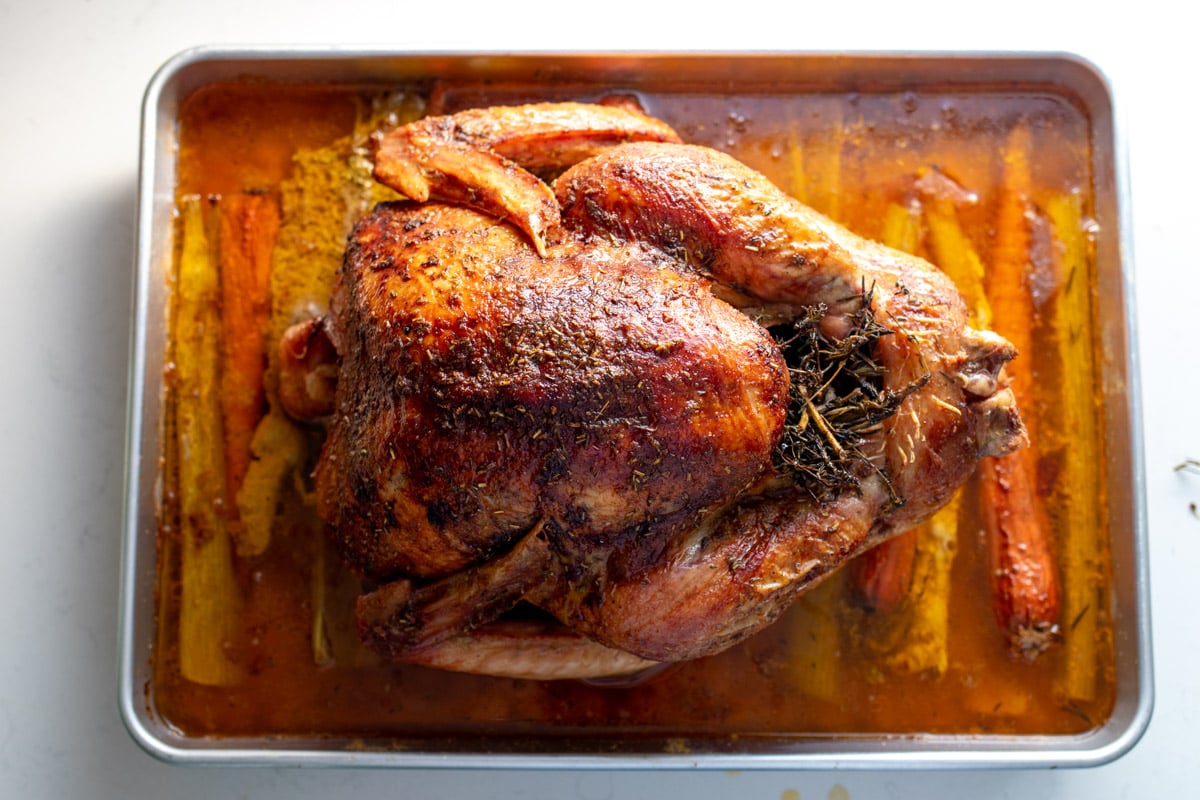 an overhead shot of a golden turkey that's been roasted with herb butter.