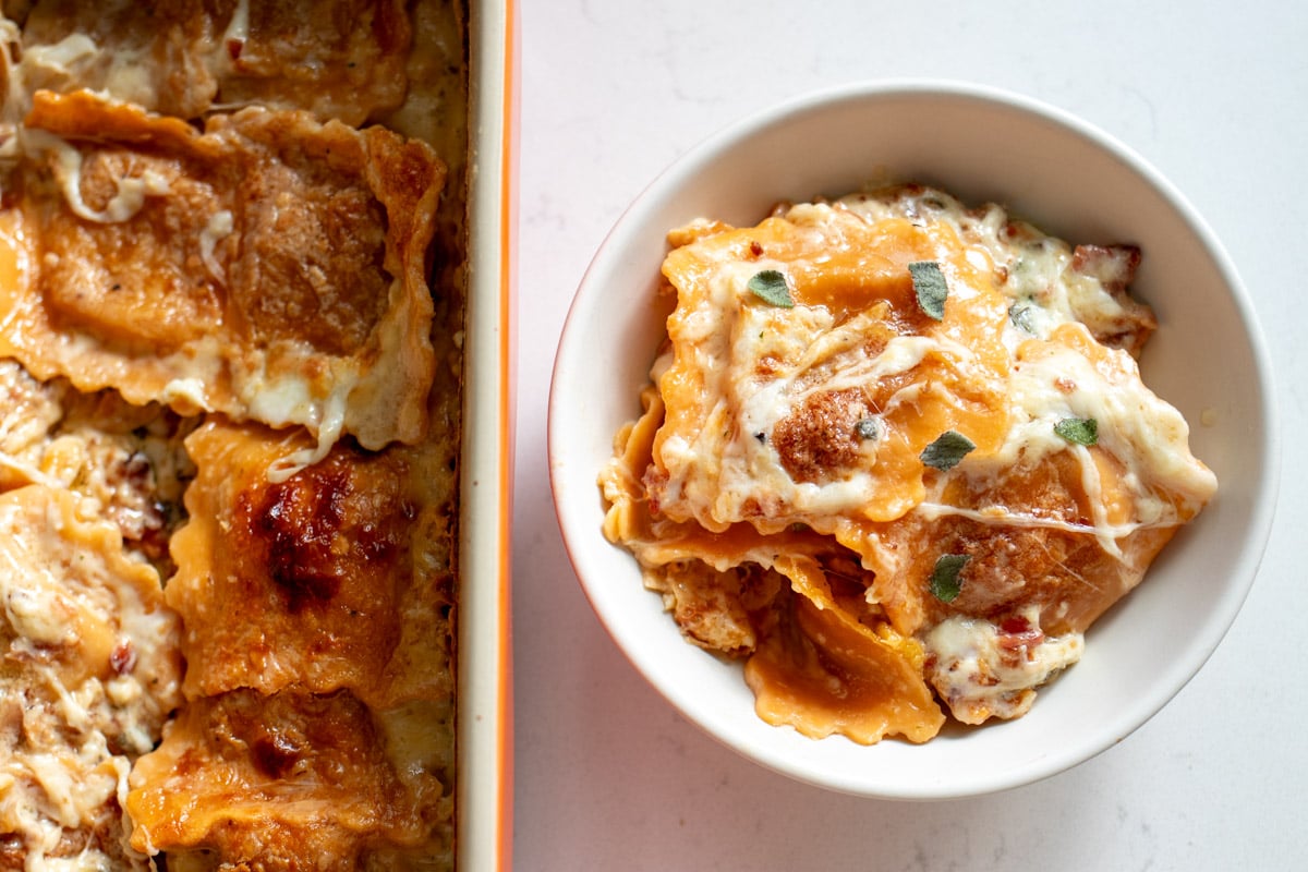 a bowl of butternut squash lasagna next to the baking dish.