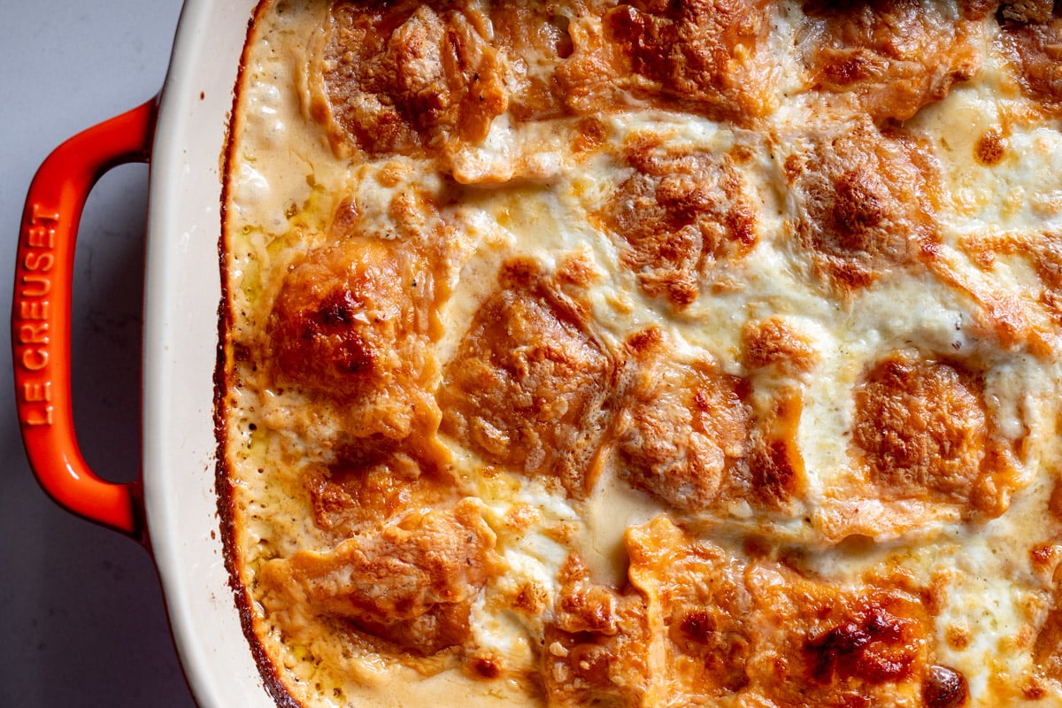 the left side of an orange baking dish full of butternut squash lasagna.