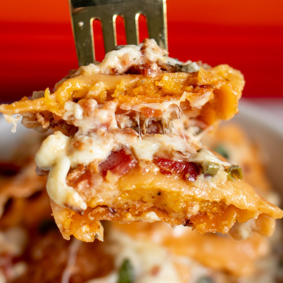 a fork holding a scoop of butternut squash lasagna.