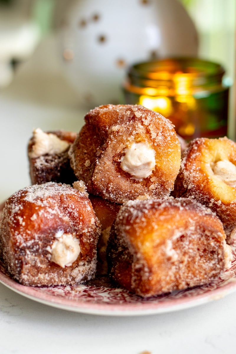a serving plate stacked with sugar coated pumpkin spiced donuts.