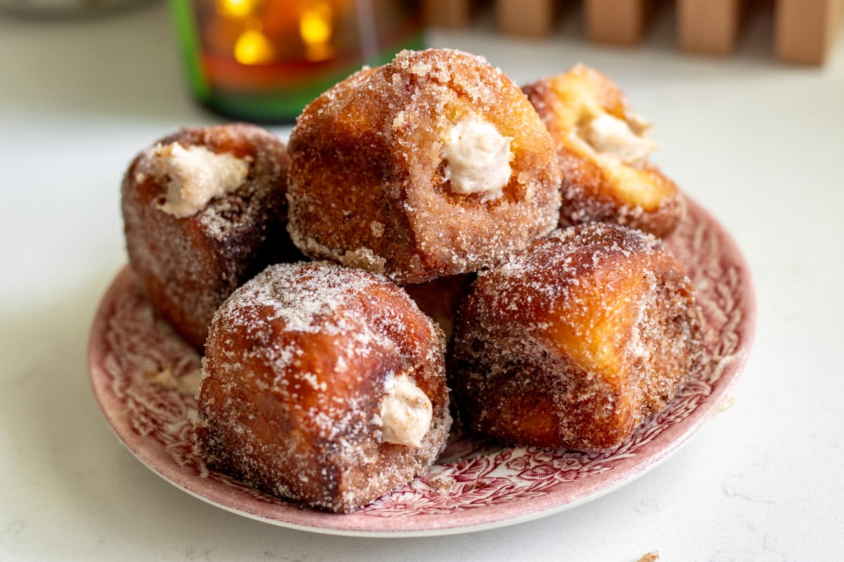 a pink and white plate full of pumpkin spice donuts that are made with kings hawaiian rolls.