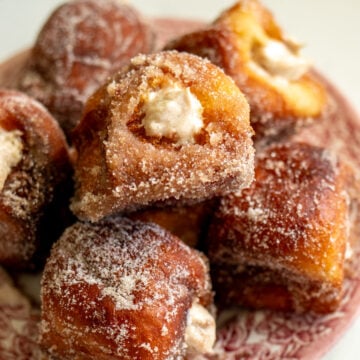 an overhead view of a plate of pumpkin spice donuts that are bursting with pumpkin spice cream cheese.