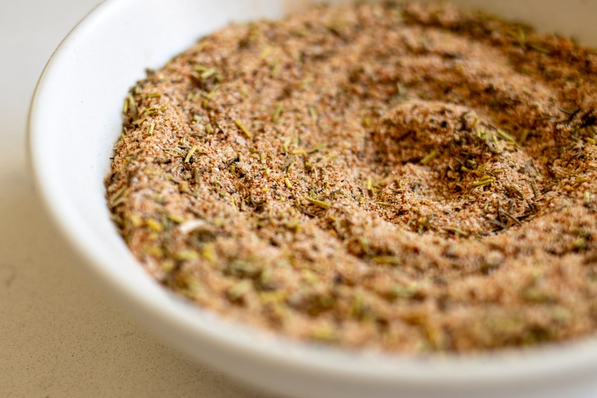 a white bowl full of spices that make up a delicious turkey seasoning blend.