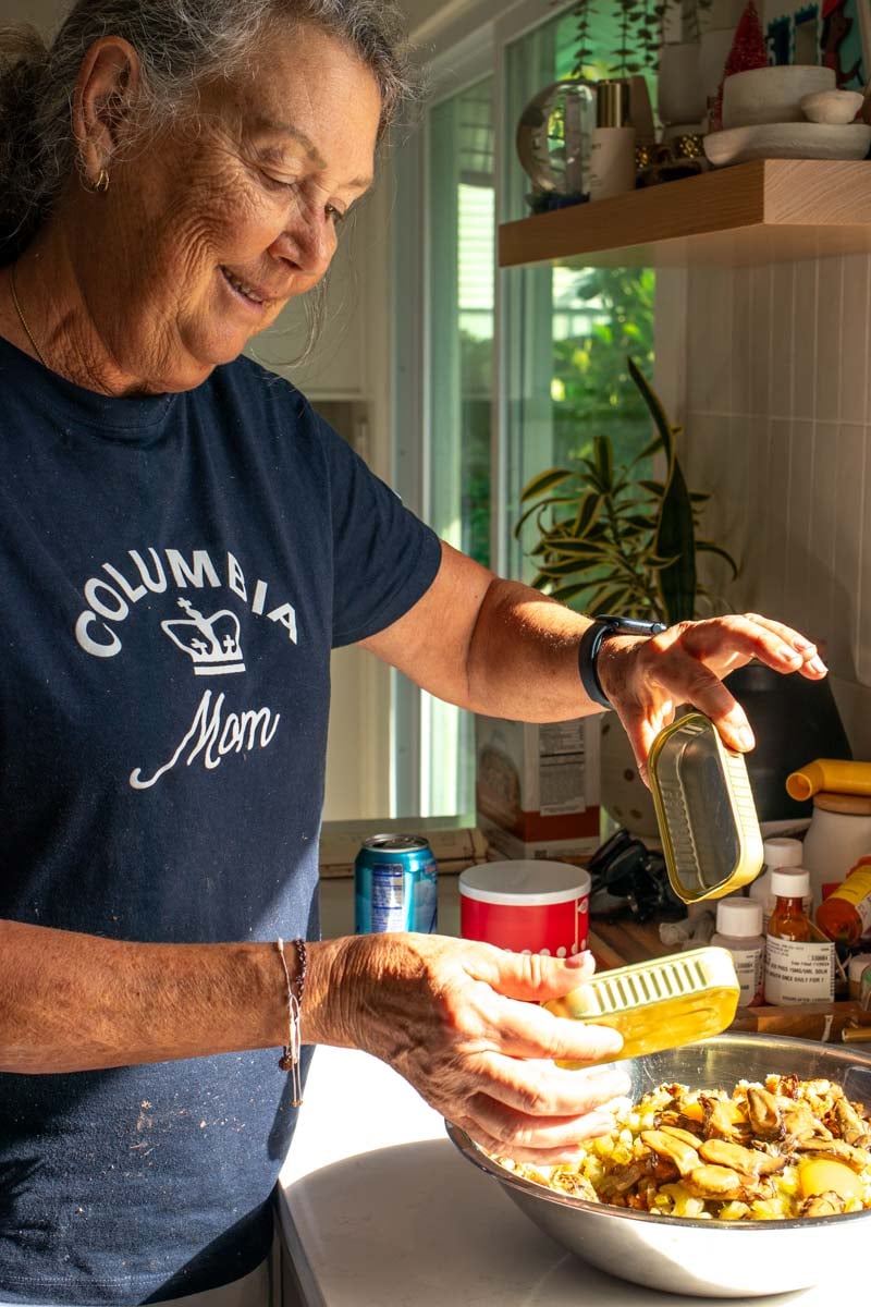 My southern mama making the oyster dressing by hand in a big silver bowl.