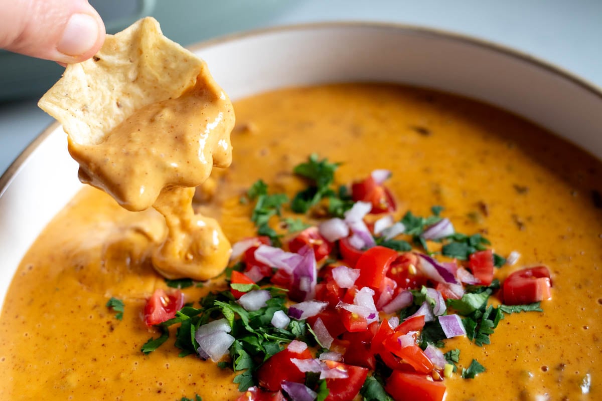 a chip scooping up a dollop of crockpot cheese dip.