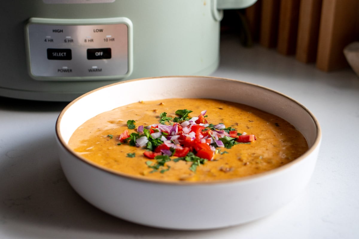 crockpot cheese dip with a green crockpot in the background.