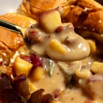 a spoon holding a scoop of melted brie and caramleized apples.