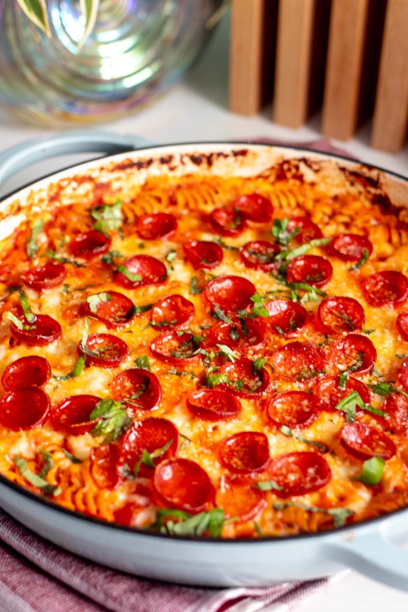 a white countertop with a blue baking dish full of pizza pasta made with high protein carbe diem pasta and cottage cheese.
