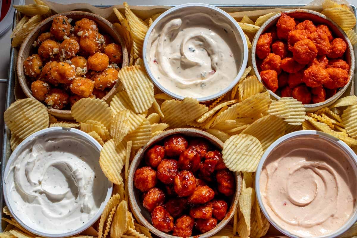 a platter of heluvagood dips, saucy nuggets and ridged potato chips.