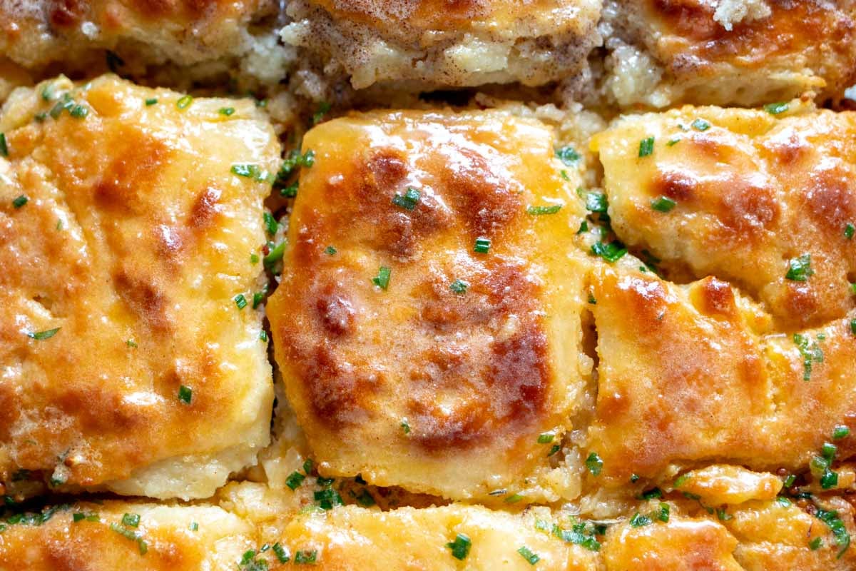 butter swim biscuits with scallion butter melted on top.