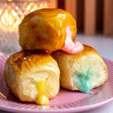 colorful icing oozing out of a tanghulu coated kings hawaiian sweet roll.