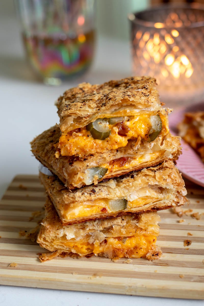 a stack of pieces of a grilled cheese pillow on top of a cutting board.