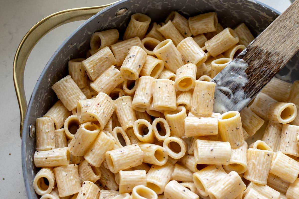 an overhead photo of pot of creamy cacio e pepe pasta.