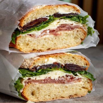 two halves of a prosciutto butter sandwich stacked on top of each other.