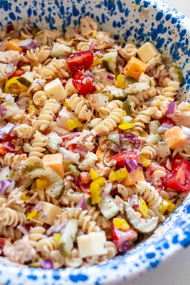 a bright and colorful sub in a tub pasta salad with turkey and cheese.