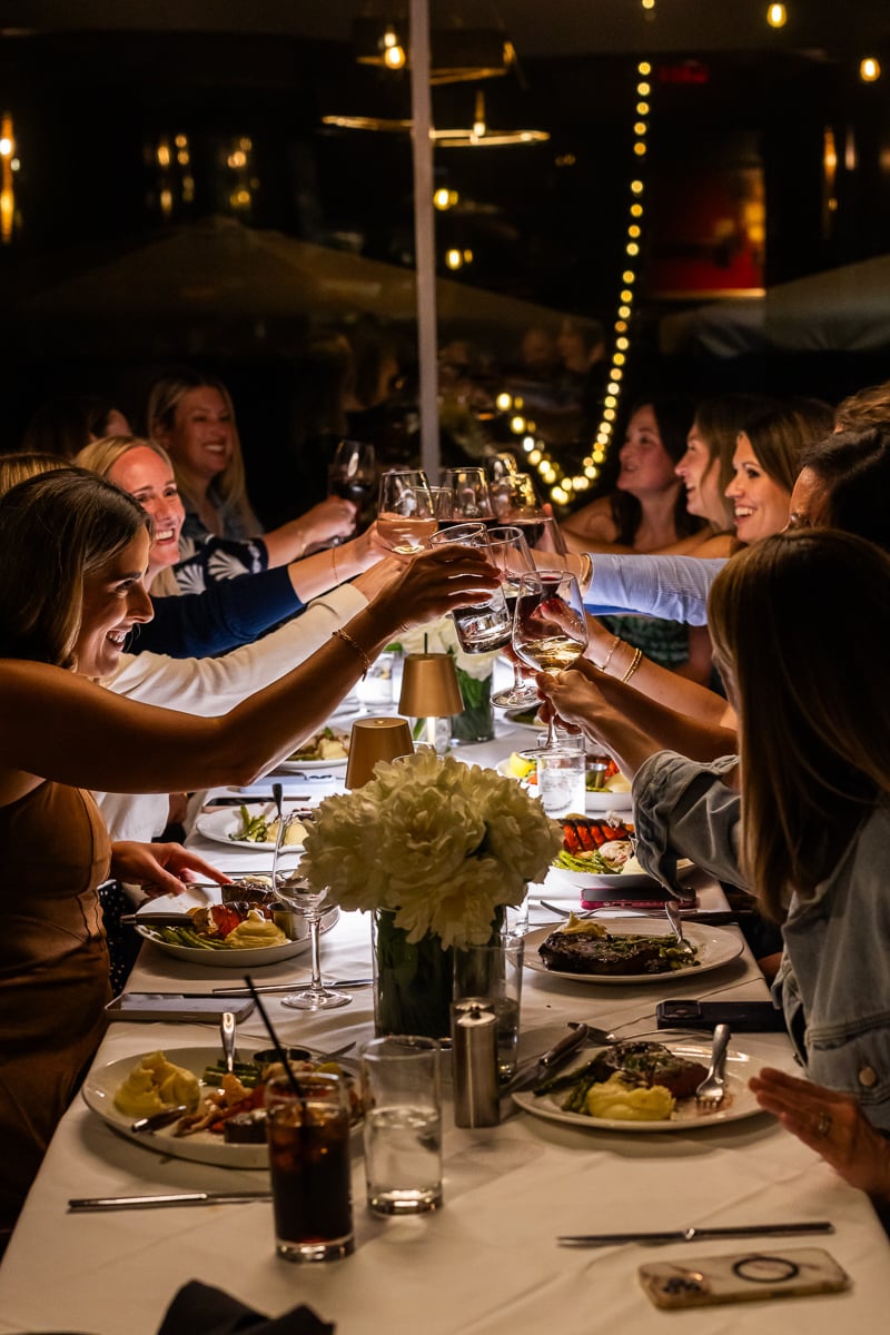 a bunch of food bloggers doing a cheers at dinner.
