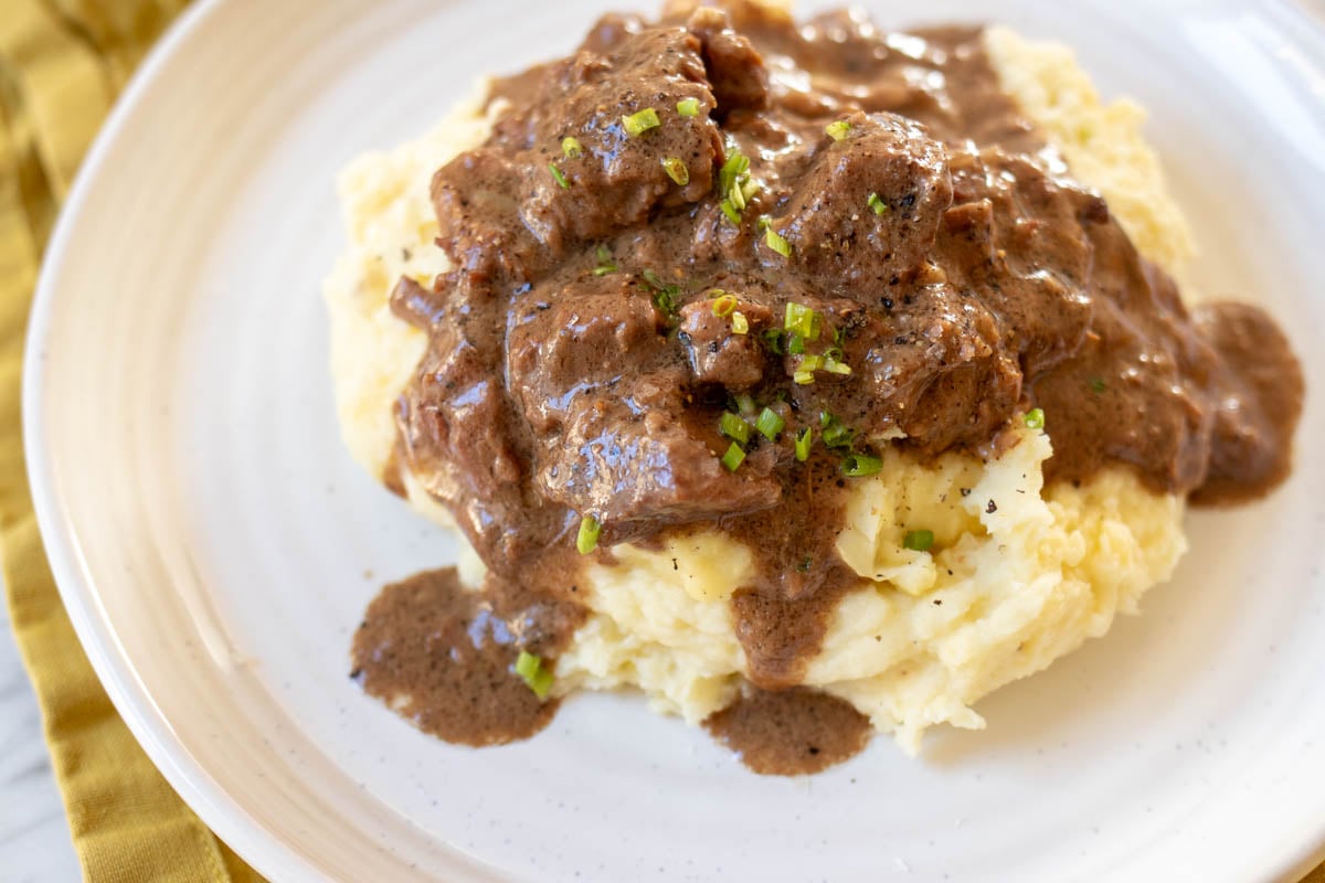 an overhead view of steak bites in a creamy peppercorn sauce.