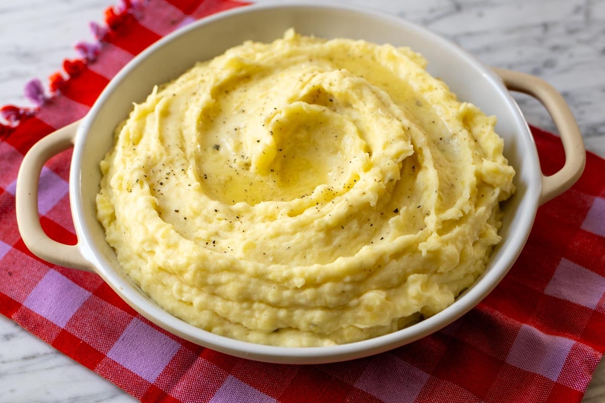 a birds eye view of super creamy luscious looking mashed potatoes with boursin cheese swirled into it.