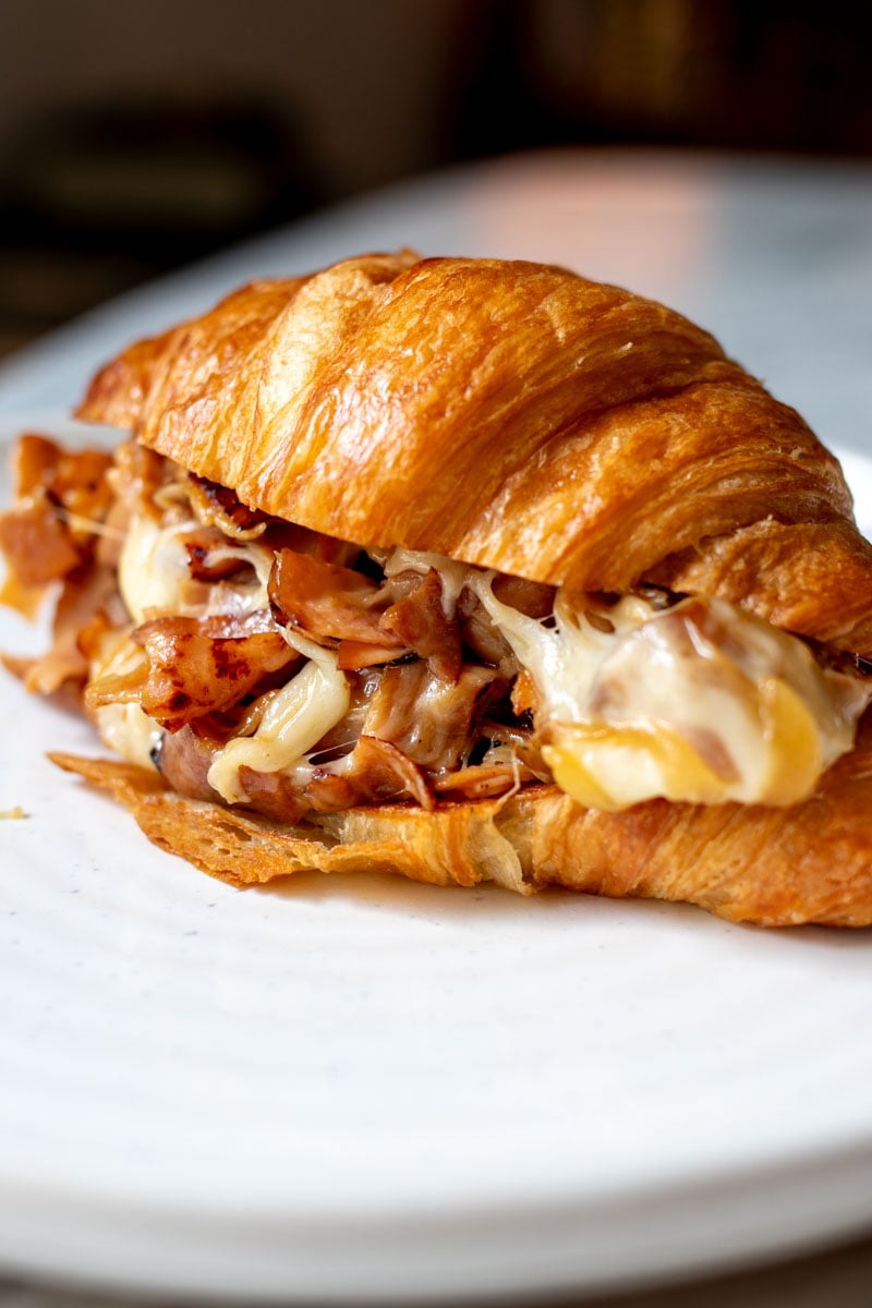 a close up of the filling inside this ham and cheese croissant.