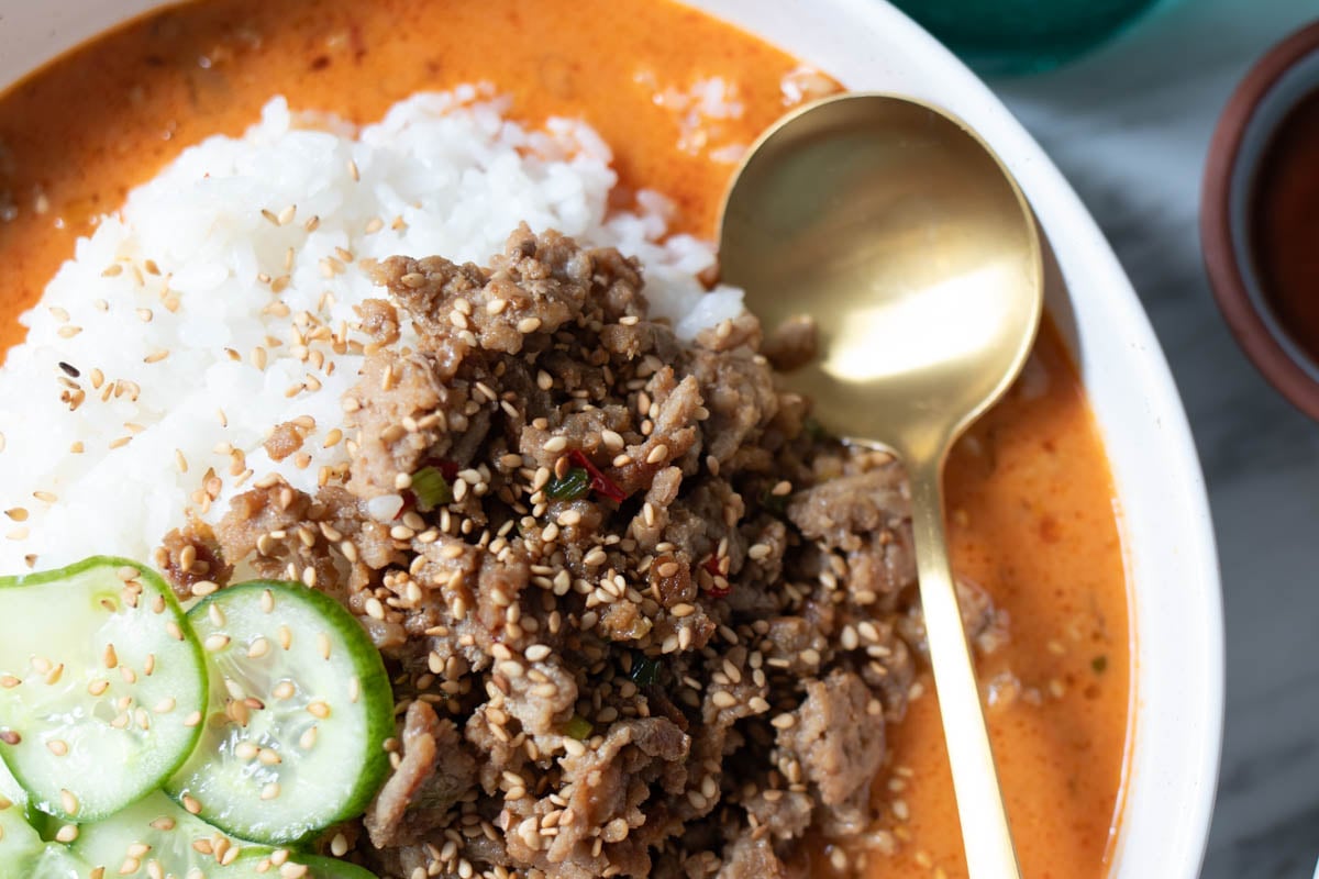 a close up of the texture of this crispy ground meat in this broth bowl.