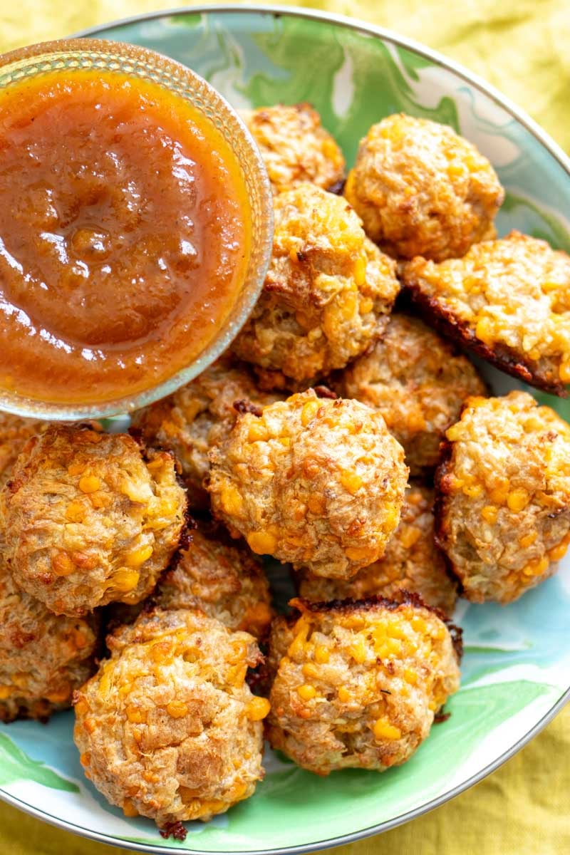 an overhead view of a platter full of cheddar apple sausage bites with apple butter dipping sauce.