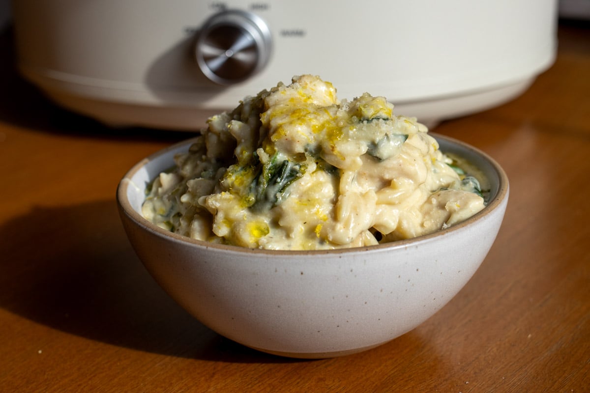 a close up of a bowl of creamy chicken orzo made in the crockpot.